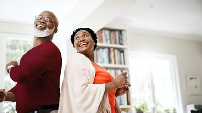 Two residents joyfully dancing in a bright common area