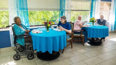 Seniors enjoying a meal in a dining room.