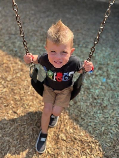A child playing on a swing in a playground