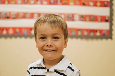 Young boy smiling in front of a colorful background