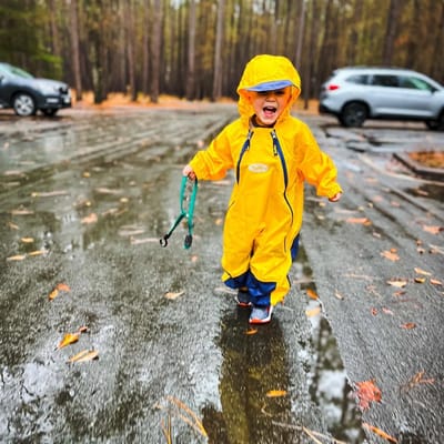 Child playing outdoors on a rainy day