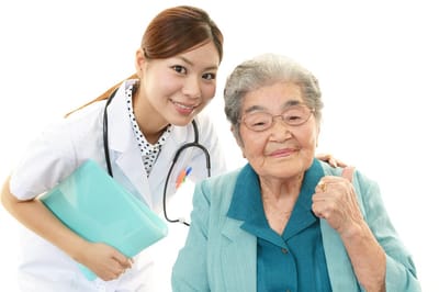 Caregiver with senior resident smiling and giving a thumbs up