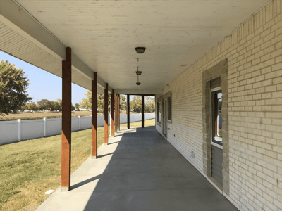 Covered patio area with pillars and grassy view