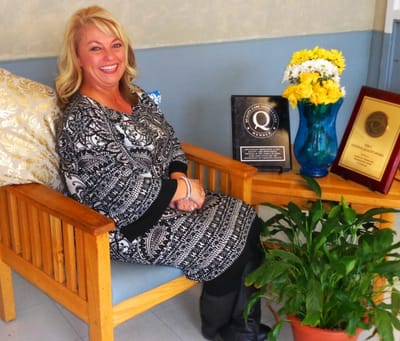 Carrollton Nursing & Rehab Ctr, Nursing Home in Carrollton, GA — Woman sitting on a bench with awards and flowers