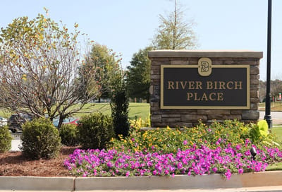 Exterior sign with landscaping at River Birch Place