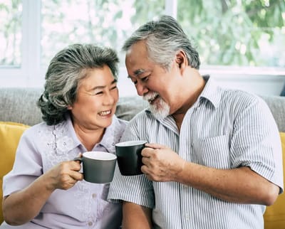 An elderly couple joyfully sharing coffee together