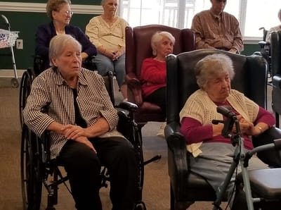 Residents sitting in a common area during an activity