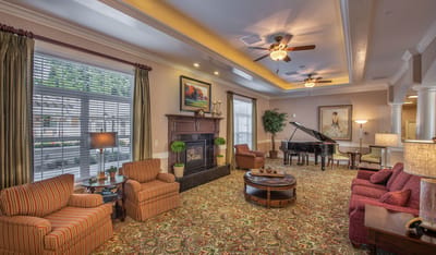 Interior of a cozy common area with seating and a piano