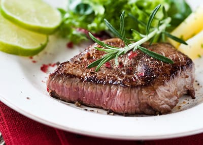 Close-up of a plated steak with garnish