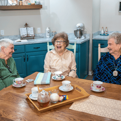 Three residents enjoying tea in a common area