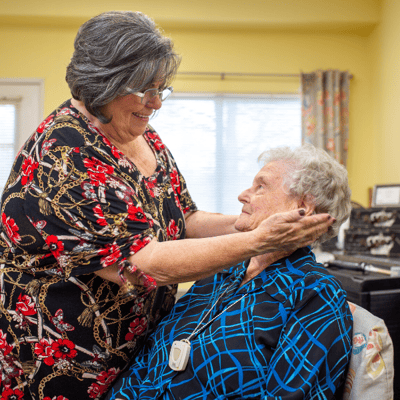 Caregiver assisting a resident with a warm smile