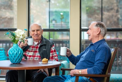 Two residents enjoying coffee in a cozy indoor setting
