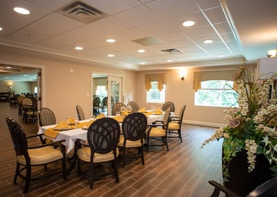 Dining area with table settings and floral arrangement.