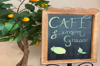 Café Lemon Grass chalkboard sign next to a decorative tree