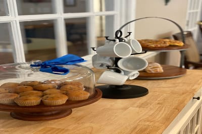 A table with muffins and coffee mugs in a cozy setting
