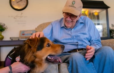 Resident interacting with a therapy dog in a common area