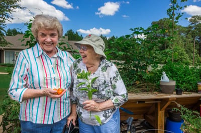 Two residents enjoying gardening outdoors