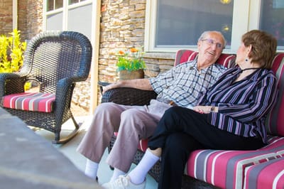 Two residents enjoying conversation on an outdoor couch