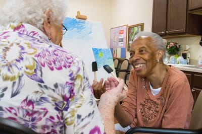 Residents engaged in a painting activity in a communal space