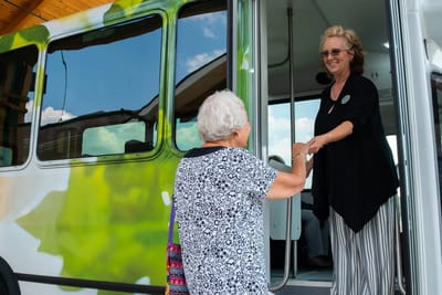 Staff member assisting a resident boarding a facility vehicle