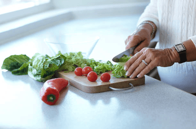 A resident preparing vegetables in a kitchen