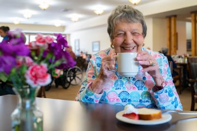Resident enjoying coffee in a cozy dining area