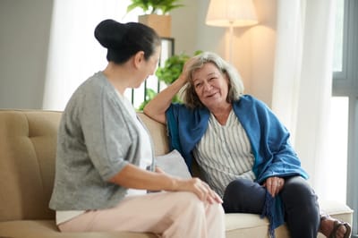 Two women conversing comfortably in a cozy interior space