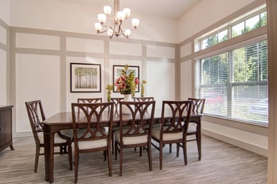Bright dining room featuring a large table and flowers