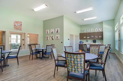 Bright common area with tables and chairs for activities
