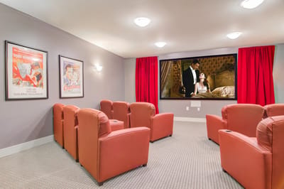 Cozy movie theater with red seating and movie posters