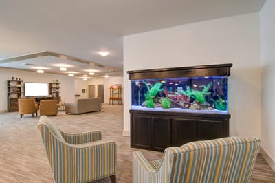 Bright common area with seating and an aquarium