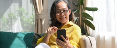 Resident enjoying their phone in a cozy living space