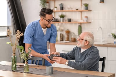 Staff assisting a resident in a modern kitchen