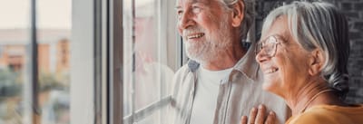 A happy couple looking out a window together
