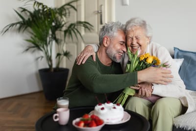 A caregiver and resident sharing a joyful moment indoors