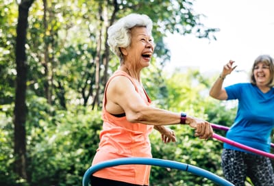 Residents enjoying hula hooping in a garden setting