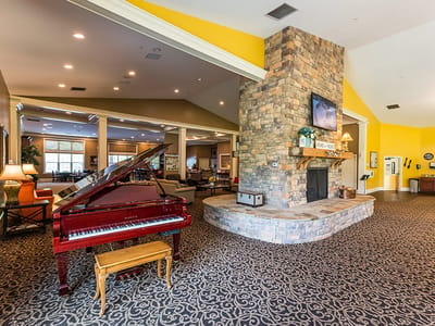 Common area with a piano and stone fireplace