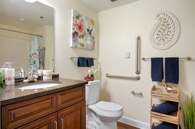Modern bathroom with floral decoration and grab bars