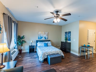 Bright, well-furnished private resident room with bed and seating area