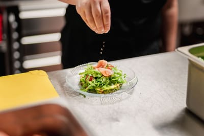 A chef preparing a salad with fresh ingredients