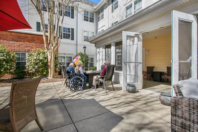 Residents enjoying a sunny outdoor space in wheelchairs
