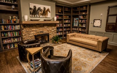 Cozy library with seating and fireplace