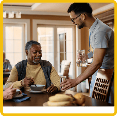 Dining area with a resident being served soup