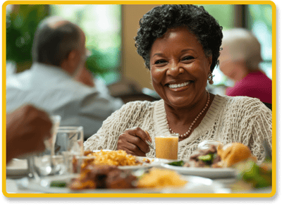 A smiling resident enjoying a meal in the dining room