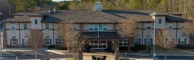 Exterior view of Ivy Springs Senior Living facility with trees