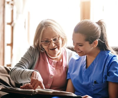 A caregiver and a resident looking at a photo album