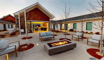 Outdoor seating area with fire pit and building entrance