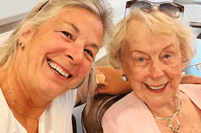 Two smiling women posing together in a friendly atmosphere