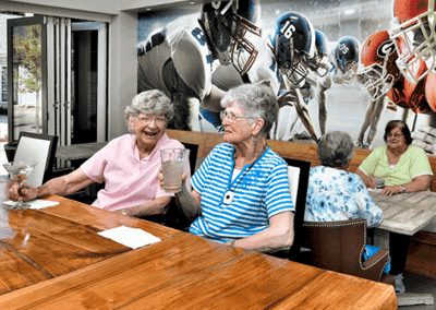 Residents enjoying drinks in a lively dining area