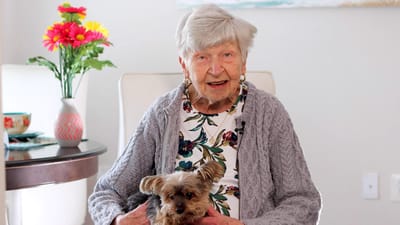 Resident holding a dog in a cozy living area